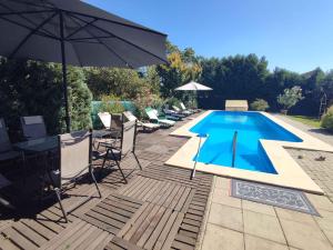 a swimming pool with a table and an umbrella at Apartments in Balatonföldvar 45318 in Balatonföldvár