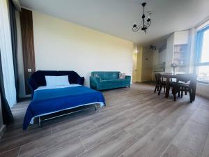 a bedroom with a bed and a table and a couch at Sunset Residence Bamboo Beach Tsikhisdziri in Ts'ikhisdziri