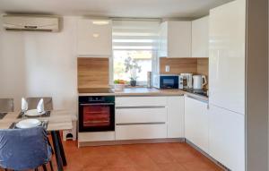 ヴィルにある2 Bedroom Amazing Apartment In Virの白いキャビネットとテーブル付きのキッチン