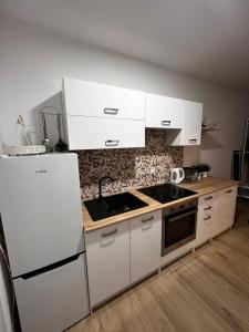a kitchen with white cabinets and a stove top oven at Relax nad Narwią u Oli I Pawła in Pultusk