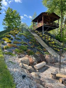 a building on top of a hill with flowers at Relax nad Narwią u Oli I Pawła in Pultusk