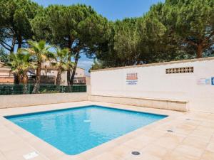 阿格德角Green Village, Maison climatisée, 6 pers, piscine, wifi, garage, terrasse的一座树木繁茂的建筑中的游泳池