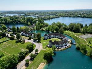 an aerial view of a house on a lake at Pepperpot Lakeside Lodge on Isis & Windrush Lakes in the Cotswold Lakes in South Cerney