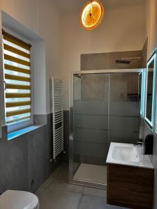 Un baño con ducha de cristal y lavabo. en La mia Griona, en Vigevano 17 fotos más