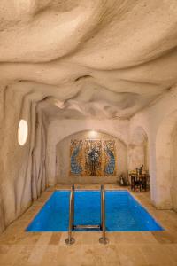 a swimming pool in a cave with a stone wall at Cappadocia Cave Suites Adult Only in Goreme