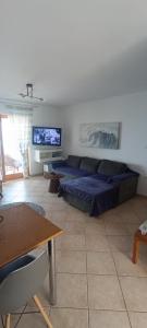 a living room with a blue bed and a tv at Villa Alba in Koinyra