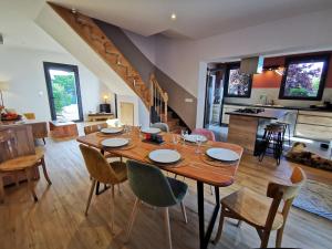 a dining room and kitchen with a wooden table and chairs at Sol i Munt Cerdanya in Enveitg