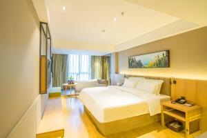una camera d'albergo con un letto e un tavolo di TRUE GO Hotel Bejing Sanyuangiao Yansha a Pechino