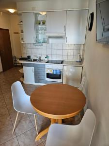 a kitchen with a wooden table and white cabinets at Apartman Ivo, Bol in Bol +13 photos