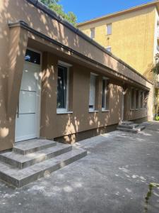 a building with stairs next to a building with a door at GreBen Apartmanok in Eger