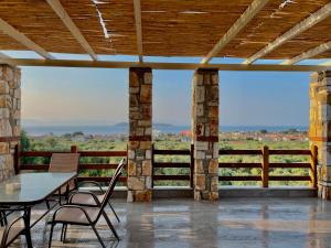 a patio with a table and chairs and a view at Helicon Luxury Villas in Limenas