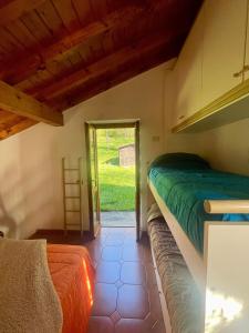 a bedroom with a bed and a door to a yard at Il Casello Bigallo in Esino Lario
