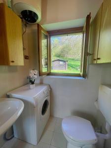 a small bathroom with a washing machine and a window at Il Casello Bigallo in Esino Lario +19 photos