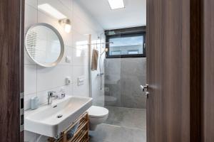 Un baño con lavabo, inodoro y espejo. en Ferienhaus Sonnenwind Hainer See Eg, en Neukieritzsch 16 fotos más