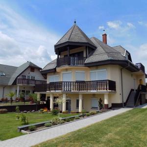 a large house with a gambrel roof at Apartment Gyenesdias 3 in Gyenesdiás