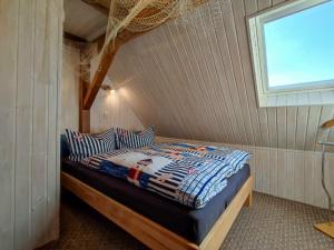 a bedroom with a bed in a room with a window at Inselromantik Rügen, App Captains Inn in Dreschvitz