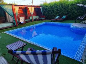 a swimming pool with a chair and a boat next to it at Villa Saturea in Boljevac