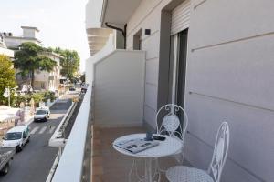 a balcony with a table and chairs and a street at Casa Plauto con appartamento grande in Bellaria-Igea Marina +10 photos