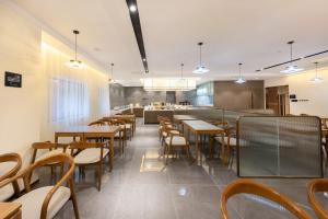 un ristorante con tavoli, sedie e un bancone di Atour X Hotel Beijing Haidian Sijiqing a Pechino