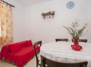 a living room with a table and a red couch at House B - 45m from the Sea in Vela Luka