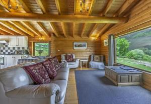 a living room with a couch and a table at Finest Retreats - Cragdhu Log Cabin in Glenshee