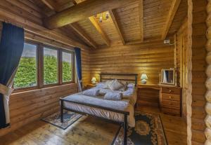 a bedroom with a bed in a log cabin at Finest Retreats - Cragdhu Log Cabin in Glenshee