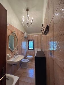 a bathroom with a sink toilet and a chandelier at Smaria Del Monte in Rosora