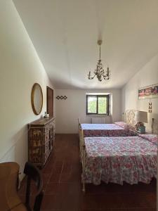 a bedroom with two beds and a mirror and a chandelier at Smaria Del Monte in Rosora