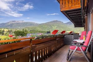 a balcony with chairs and a view of mountains at Gästehaus Etschmann in Riezlern