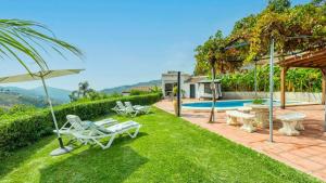 a yard with chairs and an umbrella and a pool at Casa La Lomilla Canillas de Albaida by Ruralidays in Árchez