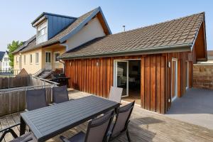 a patio with a table and chairs on a deck at Superior Duplex Apartment - nur 5 min vom Europa-Park in Rheinhausen