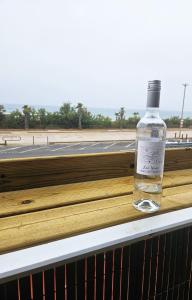 Face à la mer appartement vue mer Portiragnes plage proche Cap d'agde Vias Valras-plage Méditérranée في بورتيراني: زجاجة كحول موضوعة على حافة