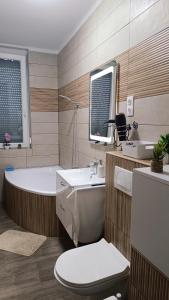 a bathroom with a tub and a toilet and a sink at Panoráma 4U in Tapolca