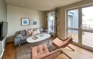 a living room with a couch and a table and chairs at Beautiful Home In Lindesnes With House Sea View in Spangereid