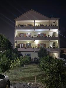 a building with balconies on the side at night at Spacious Triple Room with Balcony in Kamëz