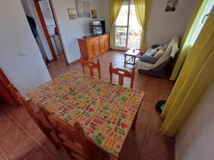 a living room with a table and chairs and a couch at Ático "El Palomar" Rooftop in Novo Sancti Petri