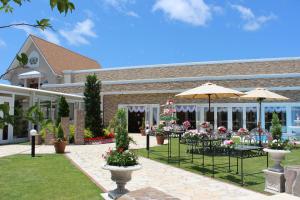 Un patio con mesas y sombrillas frente a un edificio. en 一棟貸しゲストハウス マリドール, en Izumo