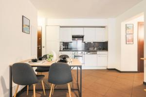 Una cocina con gabinetes blancos y una mesa y sillas. en 2Room Apart with AC, 3 min to the beach, Small garage, en Antibes