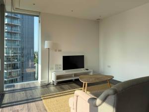 a living room with a couch and a flat screen tv at Luxury 1BR with Balcony & City Views near Aldgate in Moffat