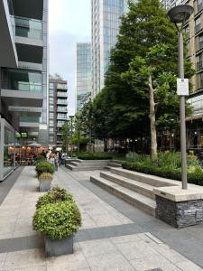 a sidewalk in a city with benches and trees at Luxury 1BR with Balcony & City Views near Aldgate in Moffat