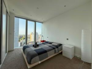 a bedroom with a large bed and a large window at Luxury 1BR with Balcony & City Views near Aldgate in Moffat