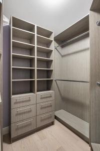 a walk in closet with wooden shelves and cabinets at The Royal Ravine Luxury Retreat in Calgary
