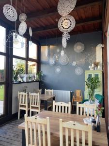 a dining room with a table and chairs and lights at Dworek Golikowo in Sławno