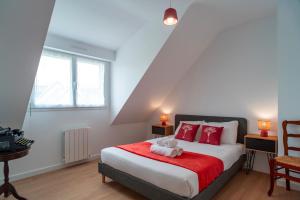 a bedroom with a bed with a teddy bear on it at Ty Kroesi - La maison du port in Arzon