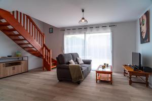 a living room with a couch and a staircase at Ty Kroesi - La maison du port in Arzon