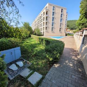 a building next to a sidewalk next to a building at Квартира студия Villa Astoria 2 Болгария Солнечный берег in Elenite