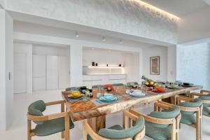 a dining room with a large wooden table and chairs at Ftelia Project in Panormos Mykonos
