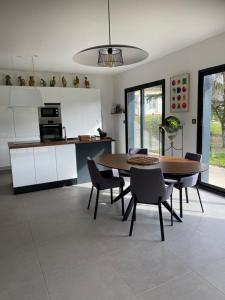 a kitchen and dining room with a table and chairs at Maison paisible proche du centre in Besançon +16 photos