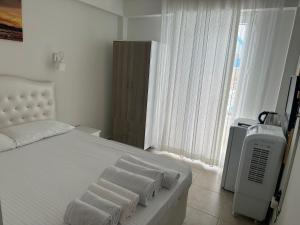 a bedroom with a white bed and a television at Casa Luma Avşa Island in Avşa Adası