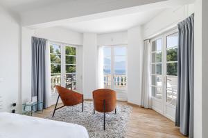 sypialnia z łóżkiem, krzesłem i oknami w obiekcie Villa Ocean Breeze w mieście Roquebrune-Cap-Martin +37 zdjęć